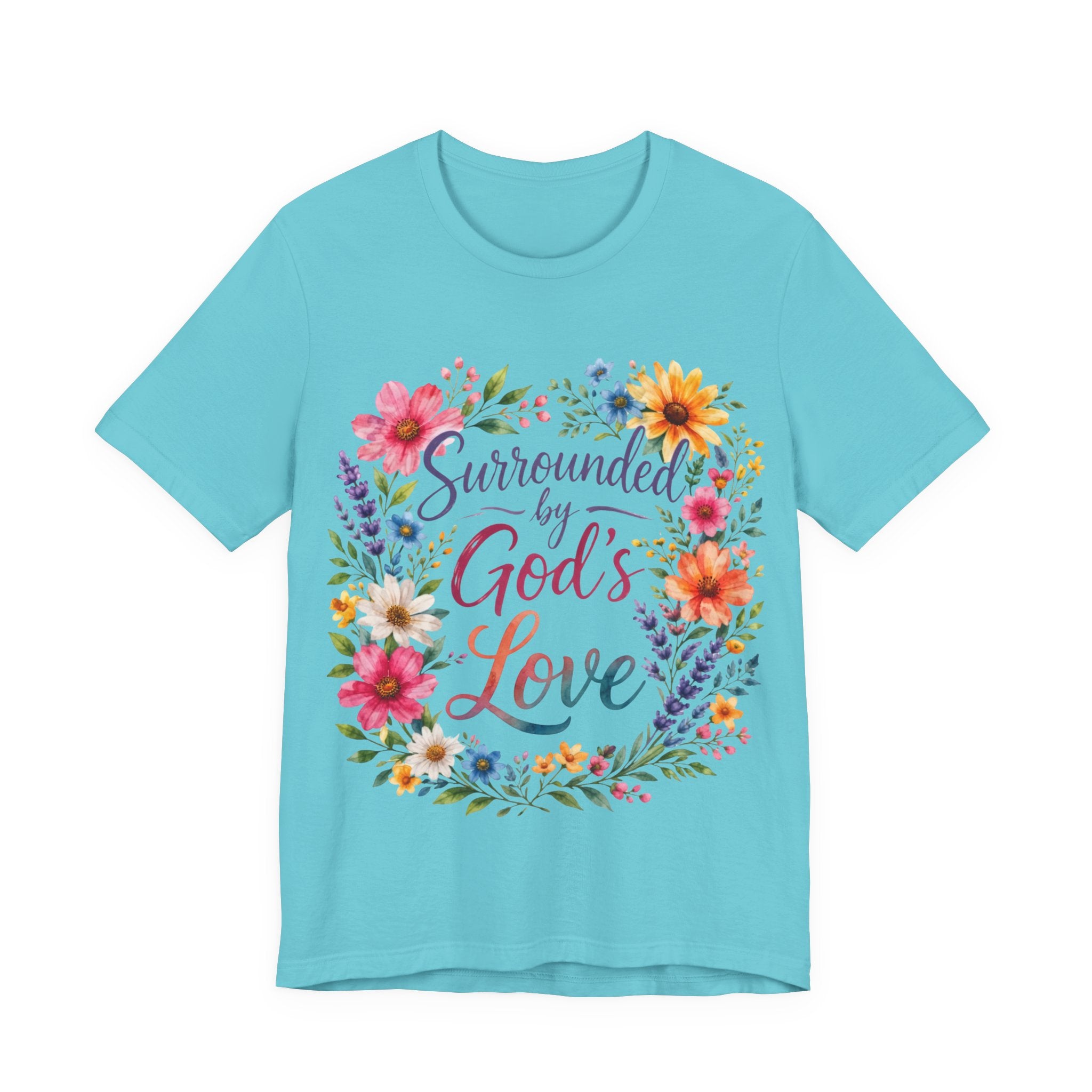 Turquoise t-shirt with colorful floral design and text 'Surrounded by God's Love' on a white background