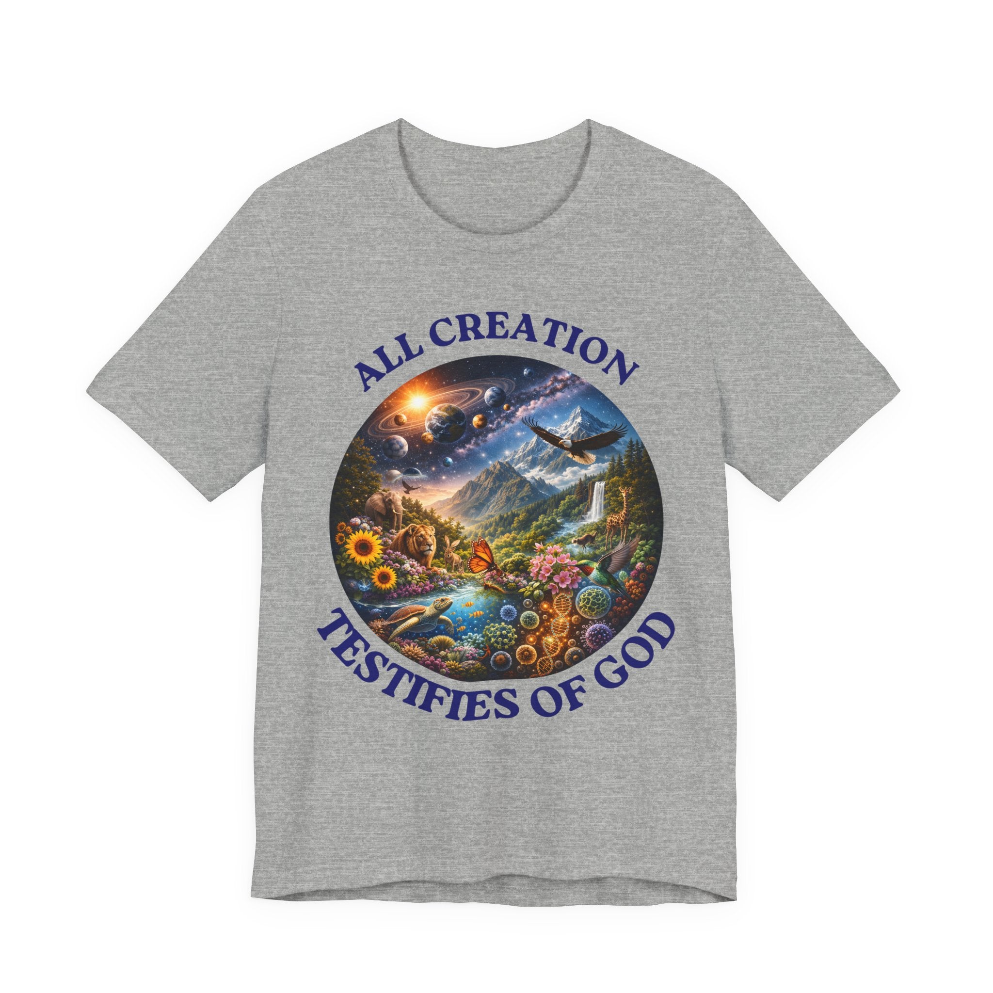 A heather gray short-sleeve crewneck t-shirt featuring a circular graphic print on the front. The graphic depicts a colorful, detailed landscape scene with a waterfall, mountains, a sun, and a bird, bordered by the blue text 'ALL CREATION TESTIFIES OF GOD'.