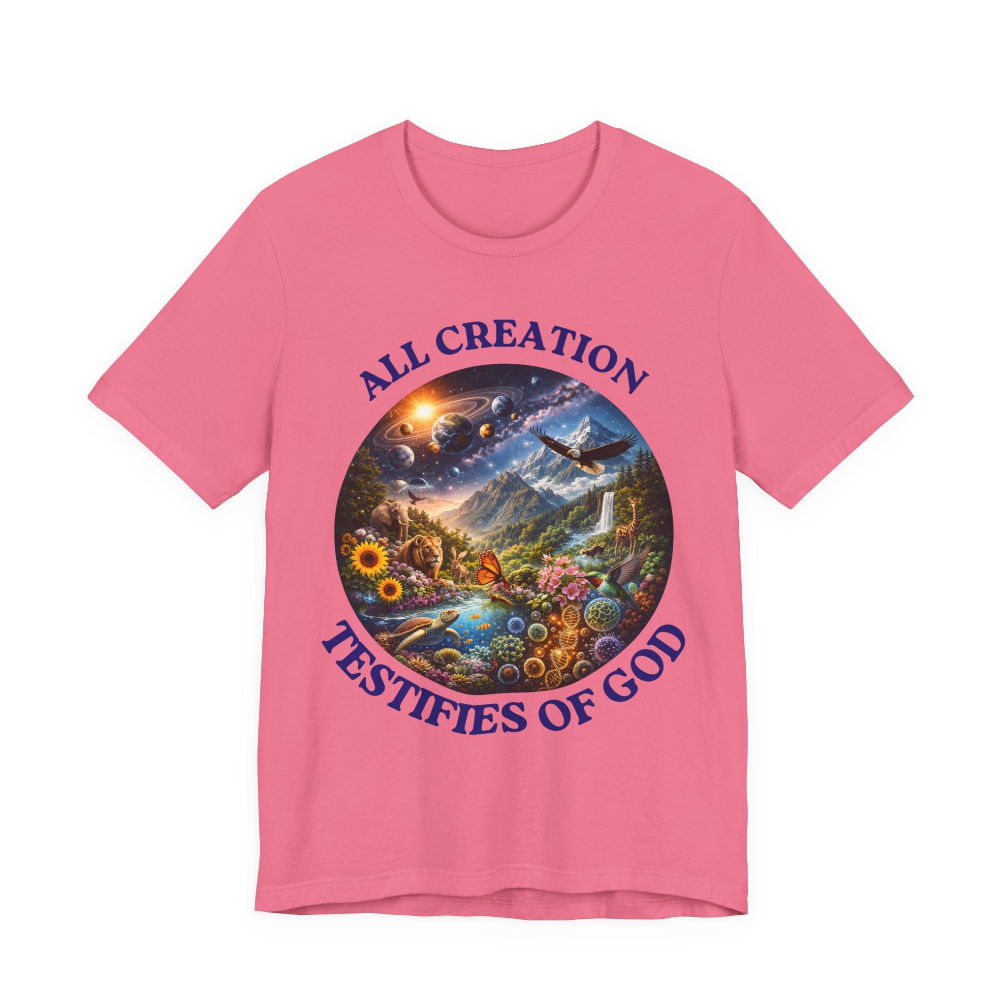 A pink short-sleeve crewneck t-shirt featuring a circular graphic of a colorful natural landscape with a sun, mountains, and a waterfall, bordered by the text 'ALL CREATION TESTIFIES OF GOD' in blue.
