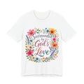 White t-shirt with colorful floral design and text 'Surrounded by God's Love' on a white background