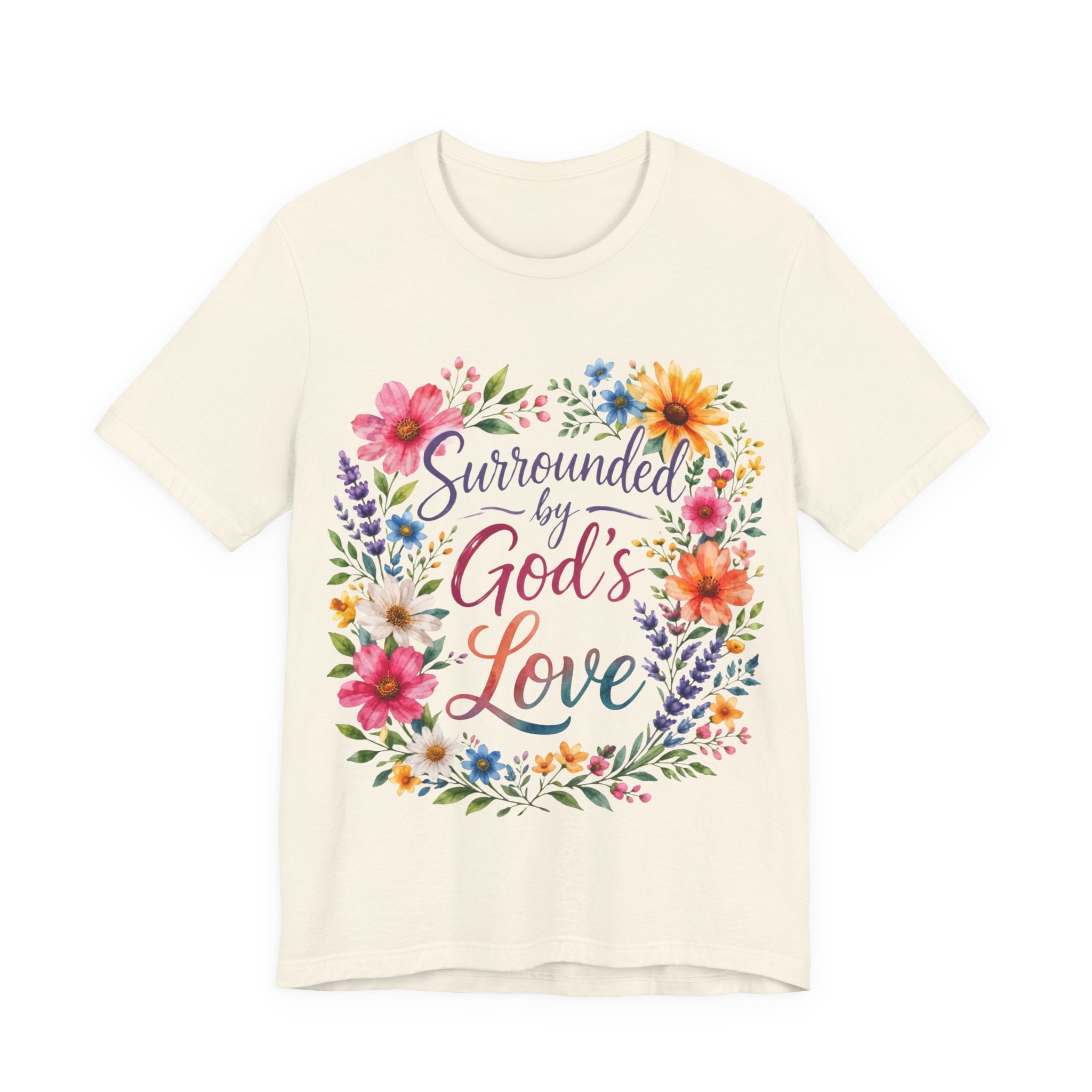 Natural t-shirt with colorful floral design and text 'Surrounded by God's Love' on a white background