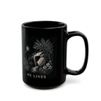Black mug with religious design and 'HE LIVES' text on a white background